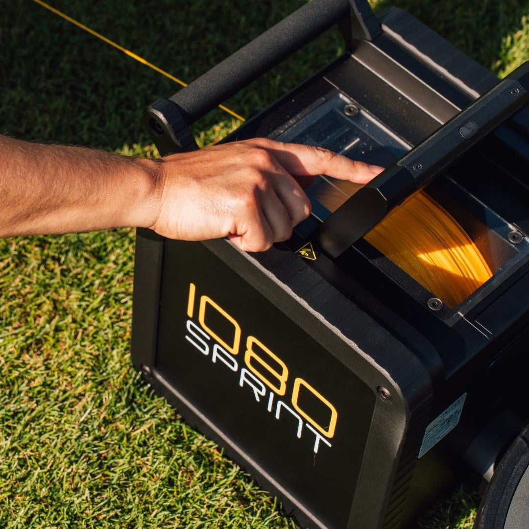operating the built-in touchscreen on a 1080 Sprint 2 speed training system outdoors on grass